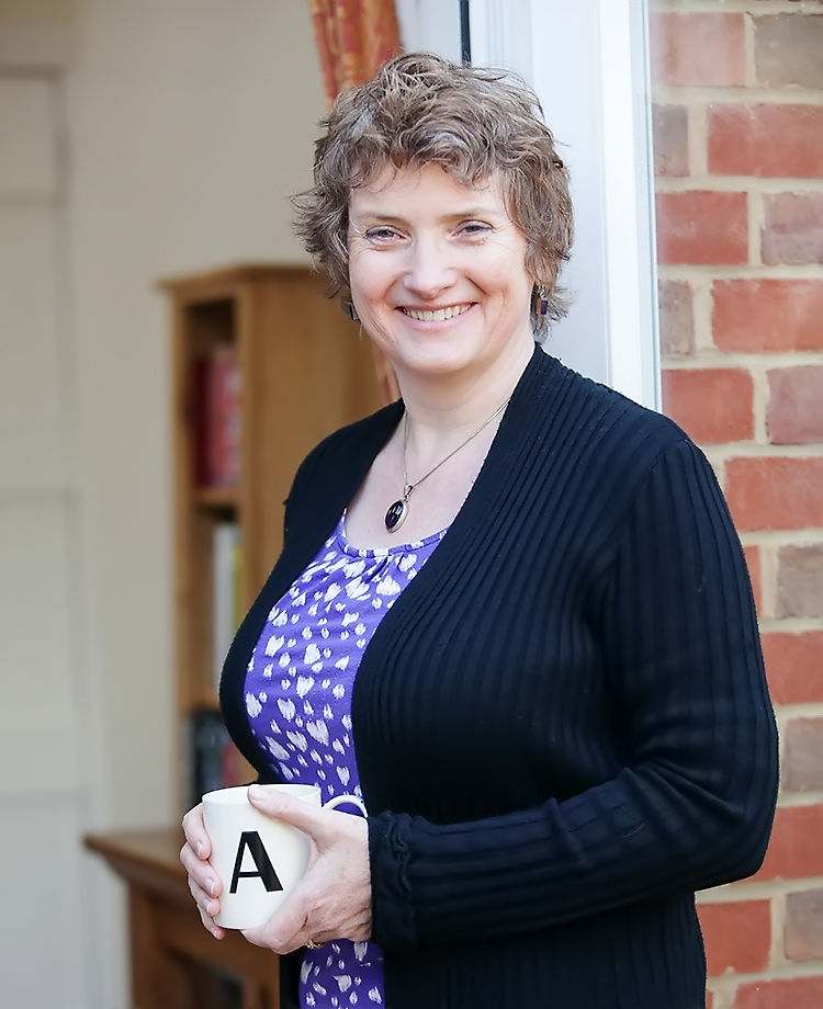 Healthcare copywriter wearing a purple shirt and black cardigan standing outside an office