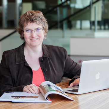 Copywriter Alison Harmer looking at a magazine