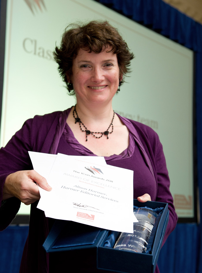 Award winning copywriter Alison Harmer in a purple top holding an award certificate to the camera