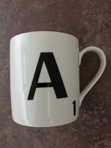 Scrabble letter A on a white mug.