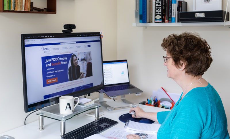 Charity copywriter Alison Harmer at a desk looking at a screen showing a not-for-profit's home page