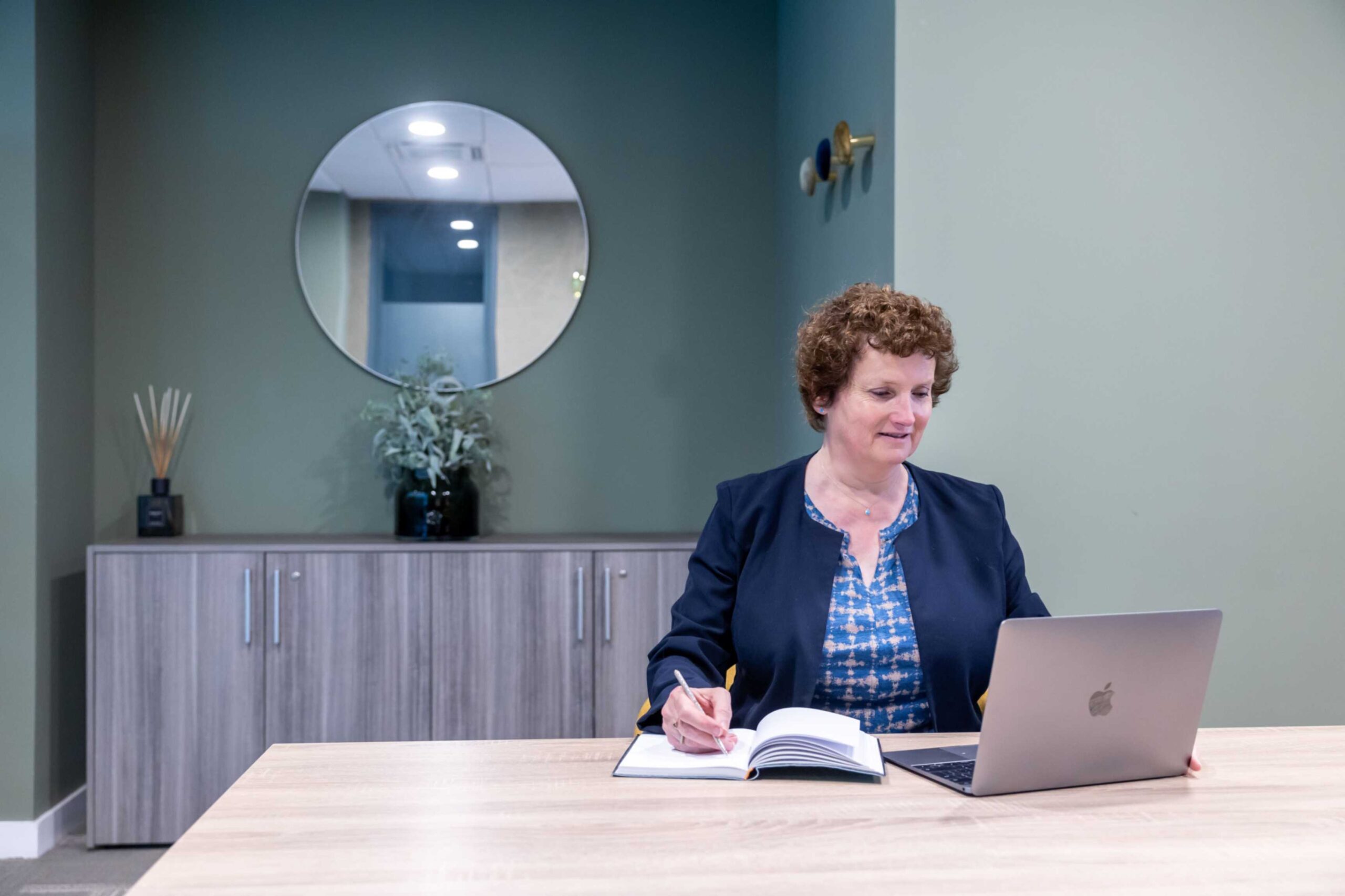 Alison Harmer looking at a laptop and writing a headline