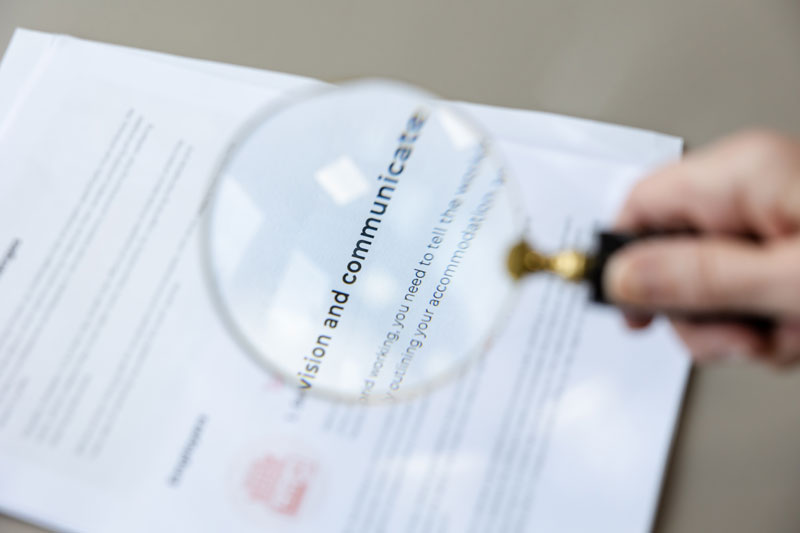 A magnifying glass with a close up of the words clear communication to show clarity as a charity copywriter